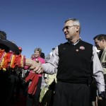 Ohio State coach Jim Tressel, center, is greeted by Fiesta Bowl ambassadors upon arrival Monday, Dec. 29, 2008, at Sky Harbor International Airport in Phoenix. Ohio State will play Texas in the Fiesta Bowl Jan. 5. (AP Photo/Paul Connors)