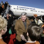 Texas coach Mack Brown is greeted by a pair of young fans and Fiesta Bowl ambassadors upon arrival Monday, Dec. 29, 2008, at Sky Harbor International Airport in Phoenix. Texas will play Ohio State in the Fiesta Bowl on Jan. 5. (AP Photo/Paul Connors)