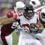 Atlanta Falcons running back Michael Turner (33) is pulled down by Arizona Cardinals' Karlos Dansby (58) as Chike Okeafor (56) defends during the first quarter of an NFL wild-card playoff football game Saturday, Jan. 3, 2009 in Glendale, Ariz. (AP Photo/Paul Connors)

