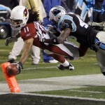 Arizona Cardinals' Larry Fitzgerald (11) reaches the ball over the goal line for a touchdown as Carolina Panthers' Chris Harris (43) defends during the second quarter of an NFL divisional playoff football game in Charlotte, N.C., Saturday, Jan. 10, 2009. (AP Photo/Chuck Burton)