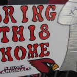 An Arizona Cardinals fan holds up a poster encouraging the team to bring home the Vince Lombardi trophy. About 1,000 fans gathered at Phoenix Sky Harbor airport on Monday, January 26, 2009 to send the team off to Tampa Bay for Super Bowl XLIII. (Jim Cross/KTAR)