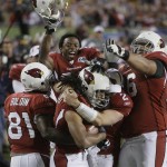 Arizona Cardinals wide receiver Larry Fitzgerald, bottom center, is congratulated by teammates after his fourth-quarter touchdown against the Pittsburgh Steelers during the NFL Super Bowl XLIII football game Sunday, Feb. 1, 2009, in Tampa, Fla. At left is Anquan Boldin. (AP Photo/John Bazemore)
