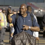 Arizona Cardinals defensive end Bertrand Berry takes a photograph of a crowd of cheering supporters before boarding a team bus upon arrival from the NFL Super Bowl XLIII football game at Sky Harbor International Airport Monday, Feb. 2, 2009 in Phoenix. (AP Photo/Paul Connors)
