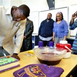 Wilson High senior Desmond Trufant cuts a cake inscribed with words from the Huskies' fight song, "Bow down to Washington," as his mom Constance snaps photos as Trufant signed a letter of intent to play NCAA college football at the University of Washington, Wednesday, Feb. 4, 2009 at Wilson High in Tacoma, Wash. (AP Photo/The News Tribune, Drew Perine)