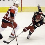 Phoenix Coyotes right winger Mikkel Boedker, right, of Denmark, shoots on goal around Carolina Hurricanes defenseman Joni Pitkanen, left, of Finland, in the first period of an NHL hockey game Saturday, Feb 7, 2009, in Glendale, Ariz. (AP Photo/Paul Connors)