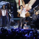 Latin star Juanes, center, and John Legend, right at piano, perform at halftime during the NBA All-Star basketball game Sunday, Feb. 15, 2009, in Phoenix. (AP Photo/Matt Slocum)