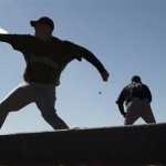 Seattle Mariners pitcher Justin Thomas, left, throws along with unidentified teammates on the first day of baseball spring training Saturday, Feb. 14, 2009 in Peoria, Ariz. (AP Photo/Charlie Riedel)