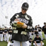 Colorado Rockies coach Jim Tracy wears a jacket with cash attached for the prize as he scores a fielding contest for players Sunday, Feb. 22, 2009, during spring training baseball in Tucson, Ariz. (AP Photo/Elaine Thompson)