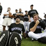 Colorado Rockies, including Ryan Spilborghs, seated at left, laugh at a teammate during a fielding contest against the center field wall Sunday, Feb. 22, 2009, during spring training baseball in Tucson, Ariz. (AP Photo/Elaine Thompson)