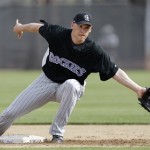 A ball gets past Colorado Rockies infielder Clint Barmes during a drill Monday, Feb. 23, 2009, during spring training baseball in Tucson, Ariz. (AP Photo/Elaine Thompson)
