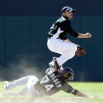 Colorado Rockies shortstop Omar Quintinalla, top, leaps over sliding Chicago White Sox's Josh Kroeger after forcing him out at second base then turning to first for a double play-attempt Thursday, Feb. 26, 2009, during their spring training baseball game in Tucson, Ariz. Quintinalla completed the turn, forcing out Dayan Viciedo at first. (AP Photo/Elaine Thompson)