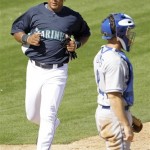 Seattle Mariners' Adrian Beltre, left, runs past Los Angeles Dodgers catcher Brad Ausmus, right, to score on a double by Bryan LaHair during the third inning of a spring training baseball game Friday, Feb. 27, 2009, in Peoria, Ariz. The Mariners won the game 18-2. (AP Photo/Charlie Riedel)