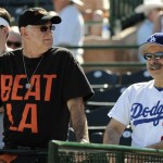 San Francisco Giants fan Don Cohn, left, of Ahwahnee, Calif., and Los Angeles Dodgers fan Michael Howard, right, of Los Angeles, wait for a baseball spring training game between the teams in Scottsdale, Ariz., Thursday, Feb. 26, 2009. (AP Photo/Eric Risberg)

