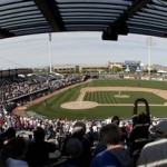 Fans stand for the seventh inning stretch during a spring training baseball game between the Los Angeles Dodgers and the Seattle Mariners, Friday, Feb. 27, 2009, in Peoria, Ariz. The Mariners won the game 18-2. (AP Photo/Charlie Riedel)