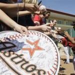Houston Astros outfielder Michael Bourn, right, signs autographs for fans before a spring training baseball game against the Pittsburgh Pirates Saturday, Feb. 28, 2009 in Kissimmee, Fla. (AP Photo/David J. Phillip)