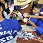 Los Angeles Dodgers pitcher Chad Billingsley, left, signs autographs before a spring training baseball game against the Chicago White Sox in Phoenix, Sunday, March 8, 2009. (AP Photo/Chris Carlson)