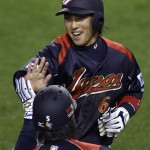 Japan's Hiroyuki Nakajima, rear, high-fives Kenta Kurihara after scoring in the third inning against South Korea during the championship game of the World Baseball Classic on Monday, March 23, 2009, in Los Angeles. (AP Photo/Ted S. Warren)