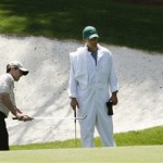 Mike Weir, left, of Canada chips onto the 13th green while his caddie watches during his practice round for the Masters golf tournament at the Augusta National Golf Club in Augusta, Ga., Monday, April 6, 2009. (AP Photo/Charlie Riedel)