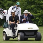Adam Scott of Australia and his caddie Tony Navarro get a ride from an official up the 13th fairway after electing to hit another ball during the second round of the Masters golf tournament at the Augusta National Golf Club in Augusta, Ga., Friday, April 10, 2009. (AP Photo/Charlie Riedel)