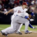 Los Angeles Dodgers' Manny Ramirez dives back to first as Arizona Diamondbacks first baseman Chad Tracy, rear, tries to field the errant throw from pitcher Jon Garland in the first inning of a baseball game Friday, April 10, 2009, in Phoenix. (AP Photo/Paul Connors)