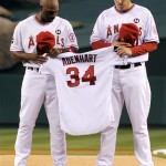 Los Angeles Angels center fielder Torii Hunter, left, and starting pitcher John Lackey pay respect during a moment of silence for Los Angeles Angels rookie pitcher Nick Adenhart who was killed early Thursday in an auto accident in Fullerton, Calif., before their baseball game with the Boston Red Sox in Anaheim, Calif., Friday, April 10, 2009. (AP Photo/Chris Carlson)