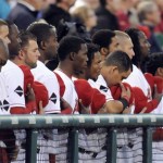 Members of the Los Angeles Angels pay their respect during the national anthem for Los Angeles Angels rookie pitcher Nick Adenhart before their baseball game in Anaheim, Calif., Friday, April 10, 2009. (AP Photo/Chris Carlson)