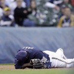 Milwaukee Brewers third baseman Bill Hall lies on the ground after missing a ground ball hit by Cincinnati Reds' Brandon Phillips during the ninth inning of a baseball game Tuesday, April 14, 2009, in Milwaukee. The Reds won 6-1. (AP Photo/Morry Gash)