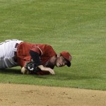 Arizona Diamondbacks' Stephen Drew eyes the ball after diving in vain for a ball hit by St. Louis Cardinals' Skip Schumaker for a single in the third inning of a baseball game Tuesday, April 14, 2009, in Phoenix. (AP Photo/Ross D. Franklin)