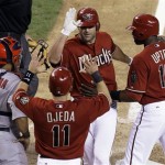 Arizona Diamondbacks' Conor Jackson, top, celebrates with teammates Augie Ojeda (11) and Justin Upton (10) after hitting a pinch-hit home run in the eighth inning against the St. Louis Cardinals in a baseball game Tuesday, April 14, 2009, in Phoenix. Cardinals' Yadier Molina is at far left. (AP Photo/Ross D. Franklin)