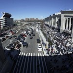 Fans arrive at the new Yankee Stadium, right, for the first regular season baseball game on Thursday, April 16, 2009, in New York. The Yankees face the Cleveland Indians in their home opener. The old Yankee Stadium appears at left. (AP Photo/Julie Jacobson)