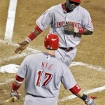 Cincinnati Reds' Brandon Phillips (4) is congratulated by teammate Laynce Nix (15) after Phillips scored on a sacrifice fly by Ramon Hernandez against the Arizona Diamondbacks during the fourth inning of a baseball game in Phoenix, Tuesday, May 12, 2009. (AP Photo/Matt York)