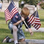 Joey Martin of Boy Scout Troop 16 places flags on the graves of veterans at West Lawn Cemetery Saturday, May 23, 2009 in Canton, Ohio. "Operation Flag" included 300 Boys Scouts, Girls Scouts, Brownies and parents as they placed 2600 American flags on grave sites in observance of Memorial Day. (AP Photo/The Repository, Scott Heckel)
