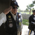 In this April 22, 2009 photo, Richard Blackaby stands at attention as a member of the honor guard carries the remains of a veteran during a internment ceremony at Riverside National Cemetery in Riverside, Calif. Blackaby, an Army veteran, is among more than 300 volunteers who honor veterans buried in the cemetery by reading their names leading up to Memorial Day each year. (AP Photo/Chris Carlson)