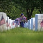 Tiger Scout Christian Pavlock, 7, carries American flags in honor of the Memorial Day holiday at Long Island National Cemetery in Farmingdale NY Saturday, May 23, 2009. (AP Photo/David Goldman)
