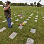 Former U.S. Marine and Vietnam veteran Gunnery Sgt. Armando Rivera Lopez, 55, pays his respects at the grave of a friend with whom he served during the last years of the Vietnam War at the National Cemetery on Memorial Day, in Bayamon, Puerto Rico, Monday, May 25, 2009. A former sniper who joined the Marines right out of high school, Rivera told the story of how he and his long-serving father both wound up helping defend different ends of Tan Son Nhat Airbase in Saigon during the U.S. evacuation in the last days of American military involvement in Vietnam. Rivera recounted how his father, who he said had served almost continuously in Vietnam since starting as an advisor in 1963, went missing in action on April 26th, 1975. (AP Photo/Brennan Linsley)