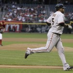 San Francisco Giants' Juan Uribe, right, heads for home after hitting a home run off Arizona Diamondbacks' Billy Buckner, left, in the second inning of a baseball game Tuesday, June 9, 2009, in Phoenix. (AP Photo/Ross D. Franklin)