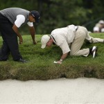 An official examines the rough off the 15th green before giving Tiger Woods, left, a ruling on his ball during the first round of the U.S. Open Golf Championship at Bethpage State Park's Black Course in Farmingdale, N.Y., Friday, June 19, 2009. Play was suspended on Thursday because of inclement weather. (AP Photo/Morry Gash)