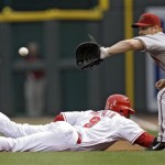 Cincinnati Reds' Danny Richar, left, dives safely back to first as Arizona Diamondbacks first baseman Chad Tracy catches a pick-off throw from Jon Garland in the third inning of a baseball game on Wednesday, July 1, 2009, in Cincinnati. (AP Photo/Al Behrman)