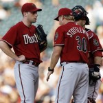 Arizona Diamondbacks starting pitcher Max Scherzer, left, confers with catcher Miguel Montero, back right, and pitching coach Mel Stottlemyre after giving up a single to Colorado Rockies' Chris Iannetta in the second inning of a baseball game in Denver on Tuesday, July 21, 2009. (AP Photo/David Zalubowski)