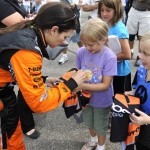 Driver Danica Patrick signs an autograph for Sarah Wright, center, and Shelby Whiteman, of Bridgeport, WV., after practice for the Honda Indy 200 auto race at Mid Ohio Sports Car Course, Friday, Aug. 7, 2009, in Lexington, Ohio. (AP Photo/Tom E. Puskar)