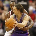 Phoenix Suns Steve Nash, front, is fouled by Portland Trail Blazers Travis Outlaw in the fourth quarter of their NBA basketball game Wednesday, Oct. 14, 2009, in Portland, Ore. The Suns defeated the Trail Blazers 110-104. (AP Photo/Rick Bowmer)