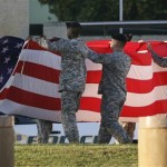 U.S. Army soldiers fold up the flag following Revile in front of the III Corp Headquarters building at Fort Hood in Killeen, Texas, Friday, Nov. 6, 2009. (AP Photo/Tony Gutierrez)