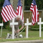 Deacon Bob Butler works of a memorial at Central Christian Church in Killeen, Saturday, Nov. 7, 2009. The memorial, 13 crosses and 30 flags, is to honor those killed and wounded in the shooting spree at Fort Hood Army Post. (AP Photo/Eric Gay)
