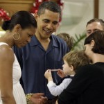 President Barack Obama and first lady Michelle Obama look at a child as they greet marines during Christmas dinner at Anderson Hall on Marine Corps Base Hawaii in Kailua, Hawaii Friday, Dec. 25, 2009. The Obamas are in Hawaii for the holidays. (AP Photo/Alex Brandon)