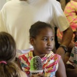 Sasha Obama, 8, turns with her shave ice as President Barack Obama waits for the next one at Island Snow in Kailua, Hawaii Friday, Jan. 1, 2010. The Obamas are in Hawaii for the holidays. (AP Photo/Alex Brandon