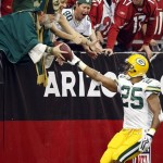 Green Bay Packers running back Ryan Grant (25) hands the football to a Packers fan after scoring a touchdown against the Arizona Cardinals during the first half on an NFL football game Sunday, Jan. 3, 2010, in Glendale, Ariz. (AP Photo/Matt York)