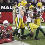 Green Bay Packers' Charles Woodson, second from right, celebrates his interception return for a touchdown with teammates Jarrett Bush (24) and Clay Matthews, front left, and Atari Bigby, back, as Arizona Cardinals' Jeremy Bridges (73) sits on the ground near teammate Beanie Wells, left, in the second quarter of an NFL football game Sunday, Jan. 3, 2010, in Glendale, Ariz. The Packers defeated the Cardinals 33-7. (AP Photo/Ross D. Franklin)