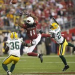 Arizona Cardinals' Larry Fitzgerald (11) goes up for a pass between Green Bay Packers' Nick Collins (36) and Charles Woodson (21) during the second half of an NFL wild-card playoff football game Sunday, Jan. 10, 2010, in Glendale, Ariz. Woodson was called for pass interference on the play. (AP Photo/Matt York)
