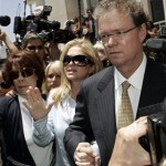 Kathy Hilton, center, gestures as she clutches her husband, Rick's hand, right, as they leave a courthouse in Los Angeles, Friday June 8, 2007. Their daughter, Paris Hilton, went sent screaming and crying back to jail Friday after a judge ruled that she must serve out her sentence behind bars rather than in the comfort of her Hollywood Hills home. (AP Photo/Damian Dovarganes)