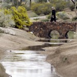 Brandt Snedeker walks on a bridge over a flooded wash on the third hole during the final round of the Phoenix Open PGA golf tournament Sunday, Feb. 28, 2010, in Scottsdale, Ariz. (AP Photo/Paul Connors)